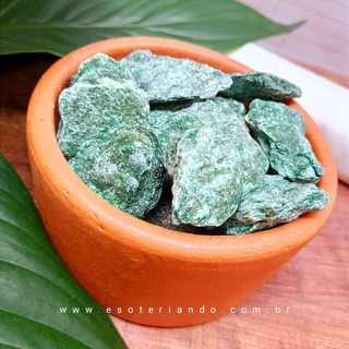 Pedra Fucshita natural, pote de cerâmica fundo de madeira e folhas verdes