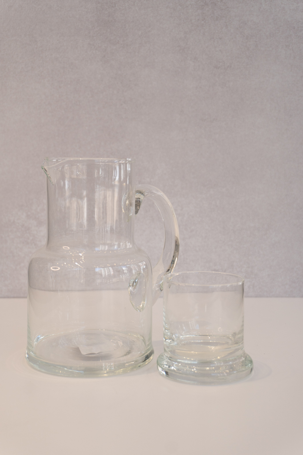 Vaso y una jarra de agua sobre la mesa de madera