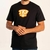 Camiseta masculina preta com estampa laranja "TKF 2020" na frente, modelo casual