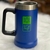 Caneca azul com detalhe em verde, apresentando a marca "we are Tuff".