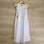 Vestido blanco para niñas con detalles de encaje en las mangas y falda larga, ideal para ocasiones especiales.