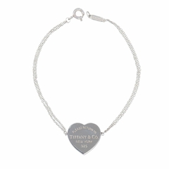 Pulseira de prata da Tiffany & Co. com pingente em formato de coração, gravado com 'PLEASE RETURN TO TIFFANY & CO. NEW YORK 925'.