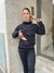 Mujer con un conjunto deportivo negro, posando en la calle, mostrando parte de su abdomen.