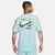 Camiseta Nike Sportswear M90 na cor azul claro, vista de costas, com estampa colorida no verso destacando o logo da Nike.