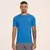 Camiseta azul de treino New Balance, modelo Sport Essentials, usada por um homem com tatuagens.