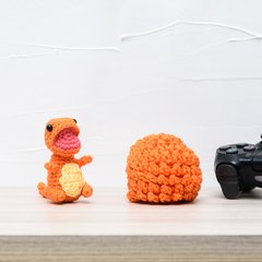 Ovo com filhote de dinossauro laranja em amigurumi na internet