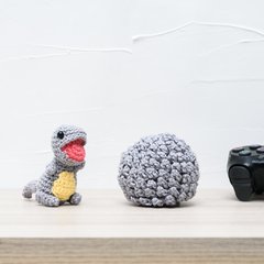 Ovo com filhote de dinossauro cinza em amigurumi na internet