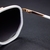 O Óculos de Sol Hexagonal 2.0 Branco possui a parte frontal confeccionada em acetato na cor branca, envolto por uma armação em metal rose e lentes degrade na cor roxa.