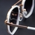 O Óculos de Sol Hexagonal 2.0 Branco possui a parte frontal confeccionada em acetato na cor branca, envolto por uma armação em metal rose e lentes degrade na cor roxa.