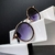 O Óculos de Sol Hollywood Rosê Preto possui um design moderno, em formato gatinho, armação em metal rosê, detalhes em acetato na cor preta e lentes degradê na cor roxa.
