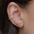 O que é um Brinco Ear Cuff com zircônias coloridas em forma de gota folheado em Ouro 18k