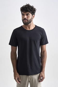 Camiseta básica preta masculina, com corte clássico e decote redondo, usada por modelo em fundo neutro.