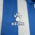 Logotipo da marca Kelme em uma camisa azul e branca do Espanyol 24/25.