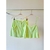 Conjunto Isadora em verde neon, composto por uma blusa sem mangas com babado e uma saia com bolsos.