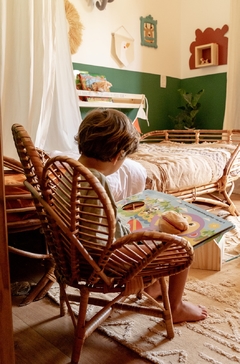 criança lendo um livro em uma cadeira flor infantil