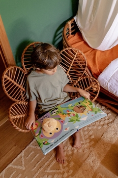 criança lendo um livro em uma cadeira flor infantil