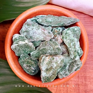 Pedra Fucshita natural, pote de cerâmica fundo de madeira e folhas verdes