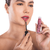 Modelo aplicando o Batom Lip Plumper Rosa Vintage