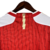 camisa-arsenal-manga-longa-home-titular-vermelha-branca-patrocinio-adidas-temporada-2023-2024-raios-faixas-laterais-W-D-invicta-gola-redonda-punhos-Emirates-Visit-Rwanda-logo-escudo-calção-meiões. 