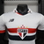 camisa-player-São-Paulo-Home-titular-temporada-2024-2025-patrocinio-New-Balance-branca-listras-vermelho-preto-escudo-NB-selo-moeda-Clube-da-Fé-calção-detalhes. 