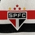 camisa-São-Paulo-Home-titular-temporada-2024-2025-patrocinio-New-Balance-branca-listras-vermelho-preto-escudo-NB-selo-moeda-Clube-da-Fé-calção-detalhes. 