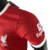 Liverpool-camisa-jogador-Nike-temporada 2023-2024-vermelha-jacquard-gola redonda-punhos brancos-97-tochas-Liver Bird-Swoosh-Standard Chartered-Expedia-calção-meiões. 