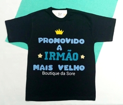 Camisa infantil preta com a frase "Promovido a Irmão Mais Velho" em letras coloridas e uma coroa amarela acima do texto.