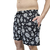 Shorts de praia masculinos com estampa de abacaxis brancos em fundo preto.