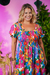 Vestido plus size floral colorido com estampas vibrantes, com decote amplo e mangas bufantes.