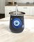 Taza de mate de acero con diseño de ojos en tonos azules sobre fondo negro.