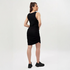 Vista posterior del vestido negro Sissi, ajustado y con detalles fruncidos, usado por una mujer joven.