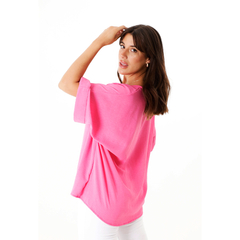 Modelo luciendo una blusa rosa de manga corta.