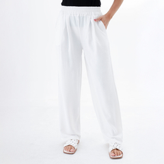 Pantalones palazzo blancos con cintura elástica y bolsillos, combinados con sandalias blancas.