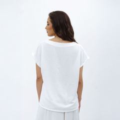 Mujer de espaldas con una remera blanca Nalami, mostrando un diseño simple y elegante.