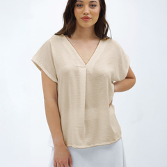 Remera Nalani en color beige, con escote en V y mangas cortas, presentada por una modelo en un fondo blanco.