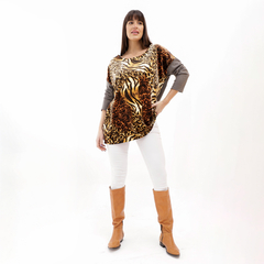 Modelo luciendo una remera Begonia con estampado de leopardo y mangas grises, combinada con pantalones blancos y botas marrones.