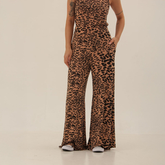 Mujer usando un mono de leopardo en tonos marrones y negros, con pantalones anchos y zapatillas blancas.