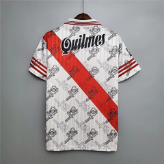 Camisa de fútbol con diseño en blanco y rojo, con el nombre "Quilmes" en la parte trasera.