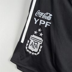 Detalle del short de entrenamiento de la Selección Argentina de Fútbol, con tres estrellas (una por cada mundial ganado) sobre el escudo de la AFA, Asociación Argentina de fútbol. Color negro, con la publicidad impresa de Coca-Cola e YPF. 