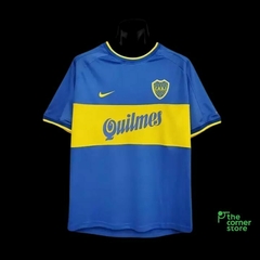 Camiseta retro de Boca Juniors, temporada 1999-2000, en color azul con franjas amarillas y el logo del club.