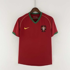 Camiseta de la selección de fútbol de Portugal, utilizada en la temporada 2006. Color rojo, con cuello y detalle en el extremo de mangas, en color verde.