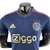 Camisa Reserva do Ajax temporada 2022/23 Masculina Jogador  Adidas - com a cor azul escura como base e detalhes em vermelho e dourado. O escudo do clube é aplicado em dourado com as três estrelas superiores em vermelho. A gola redonda traz um padrão geomé