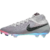 chuteira de campo Nike Phantom Luna II Elite AS FG Rising Gem. A chuteira possui um cabedal cinza Atmosphere com detalhes em preto. O Swoosh da Nike apresenta um padrão geométrico. A sola é rosa e iridescente.