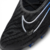 Chuteira Nike Phantom GX Elite FG Shadow em close-up, destacando o material Nike Gripknit na parte superior da chuteira, com detalhes em preto, azul e cinza.