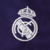 quarta camisa do Real Madrid 2024/25 na cor roxa. A camisa possui duas rosas em tom sobre tom, uma na parte superior direita e outra na parte inferior esquerda com a assinatura de Yohji Yamamoto. A gola é redonda, as mangas e punhos são da mesma cor roxa 