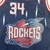 Regata reserva do Houston Rockets da temporada 1995-1997, produzida pela Mitchell & Ness. A imagem mostra a regata nas cores azul marinho, branca e vermelha, com os logotipos da equipe e da NBA. Na parte frontal, o nome "Rockets" aparece em destaque