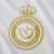 nova terceira camisa do Al-Nassr, da Adidas, para a temporada 2024/2025. A camisa, predominantemente branca, possui detalhes em dourado nos arcos laterais e axilas, além das três listras características da Adidas nos ombros.