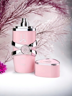 Frasco de perfume Lattafa Yara en color rosa con tapa plateada, acompañado de un estuche en forma de corazón.