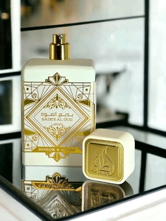 Frasco de perfume Lattafa Bade'e Al Oud Honor & Glory sobre un espejo, con un diseño elegante en tonos dorados y blancos.