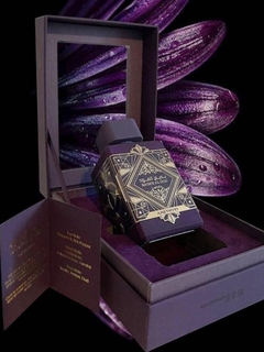 Frasco de perfume Lattafa Bade´e Al Oud Amethyst en su caja elegante, con fondo de pétalos morados.